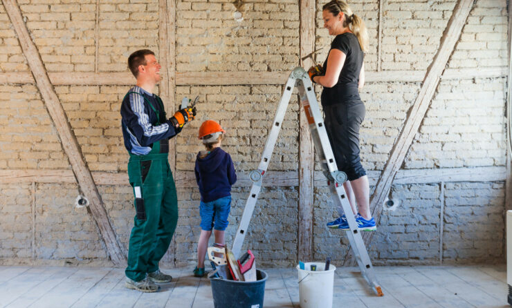 Was sollten Sie zum Thema Eigenheimfinanzierung wissen? (im Bild: eine dreiköpfige Familie beim Handwerken)